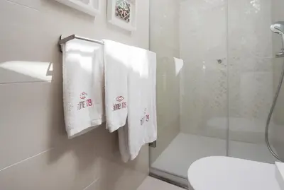 a bathroom with white towels hanging on a wall at HM - Flores Skylight in Porto
