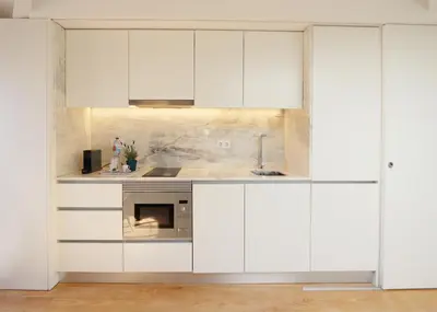 a kitchen with white cabinets and a sink at HM - Flores Skylight in Porto