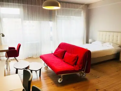 a bedroom with a red couch and a bed at Bolhão Studio in Porto