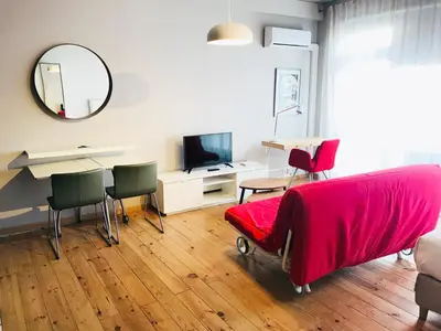 a bedroom with a bed with a red blanket and chairs at Bolhão Studio in Porto