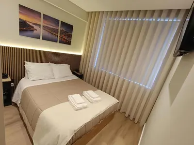 a bedroom with a bed and a window with a television at Feel Porto in Bolhão 