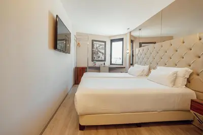 a bedroom with a large bed with a large headboard at ABC Hotel Porto - Boavista in Porto