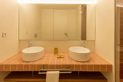 two sinks in a bathroom with a mirror at Garça Real Flats in Porto