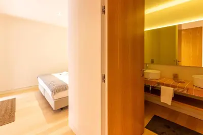 a bathroom with two sinks and a bed and a mirror at Garça Real Flats in Porto