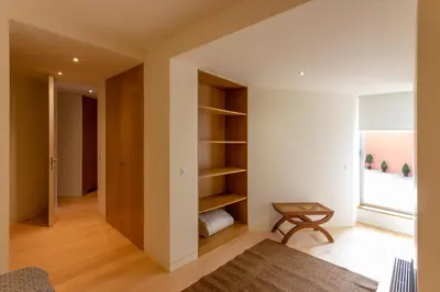 a room with white walls and wooden shelves at Garça Real Flats in Porto