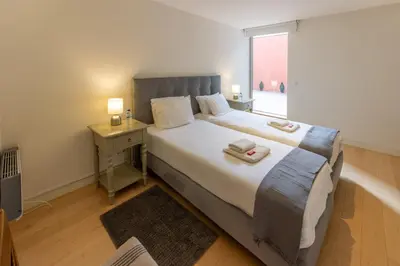 a bedroom with a large bed and a window at Garça Real Flats in Porto