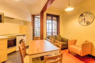 a kitchen and living room with a table and chairs at Garça Real Flats in Porto