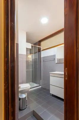 a bathroom with a shower and a toilet and a sink at Garça Real Flats in Porto