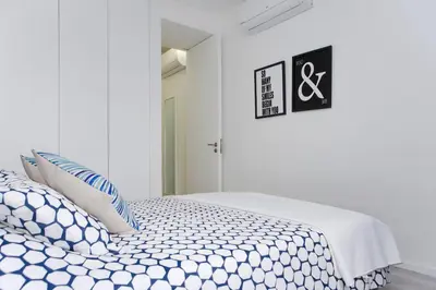 a bedroom with a bed with blue and white pillows at My Modern Homey at Porto in Porto