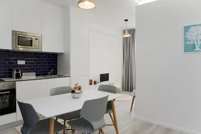 a kitchen and dining room with a white table and chairs at My Modern Homey at Porto in Porto