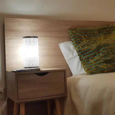 a lamp on a night stand next to a bed at À Francos Metro in Porto