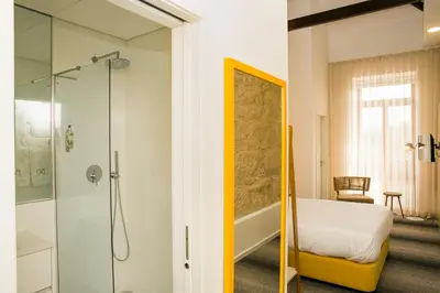 a bathroom with a bed and a glass shower at BO - Álvares Cabral GuestHouse in Porto