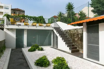 a house with a balcony with chairs and a staircase at BO - Álvares Cabral GuestHouse in Porto