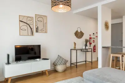 a living room with a tv on a white wall at FT'Studio in Porto