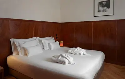 a bedroom with a bed with towels on it at Casa Rosa in Porto