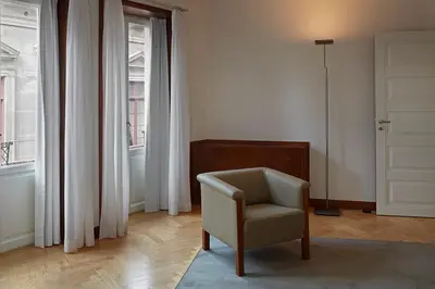 a white room with a chair and a window at Casa Rosa in Porto