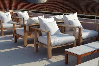 a row of chairs with white pillows on a roof at Casa Rosa in Porto