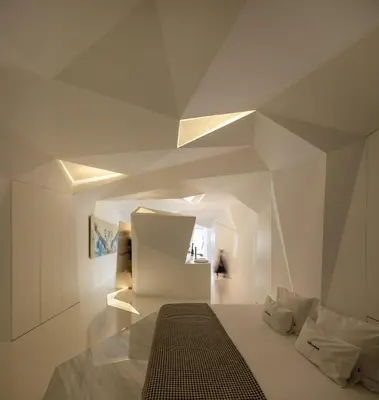 a white room with a bed and a geometric ceiling at LeBlanche in Porto