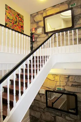 a staircase in a home with a stone wall at Duas Nações Guest House in Porto