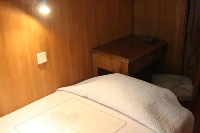 a small bedroom with a bed and a wooden wall at Duas Nações Guest House in Porto