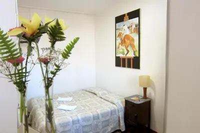 a bedroom with a bed and a vase of flowers at Duas Nações Guest House in Porto