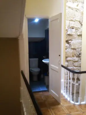 a hallway leading to a bathroom with a toilet at Duas Nações Guest House in Porto