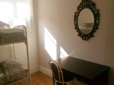 a room with a mirror and a desk and a bed at Duas Nações Guest House in Porto