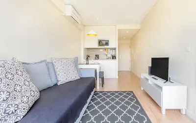 a white bedroom with a large bed and a rug at Trindade Flat with Great View in Porto