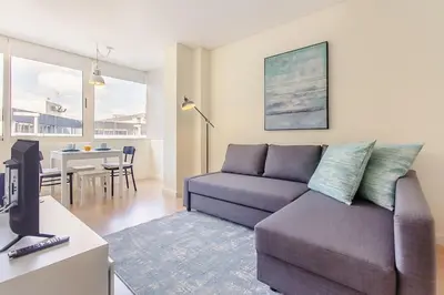 a living room with a couch and a kitchen at Trindade Modern Flat (with Air Conditioning) in Porto