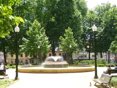 a fountain in a park with people sitting on benches at Gabriel Guesthouse in Porto