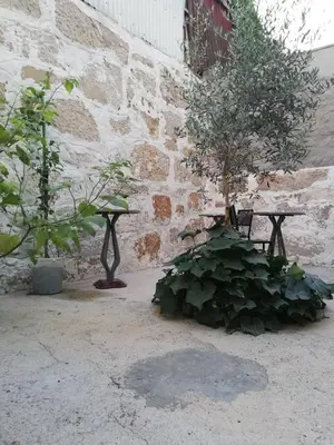 a bench and trees in front of a brick wall at Gabriel Guesthouse in Porto