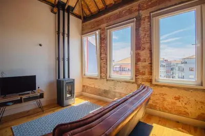 a room with a couch and a tv and windows at Step In Porto Apartments in Porto
