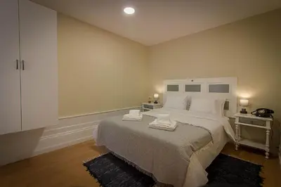 a bedroom with a large bed with two towels on it at São Domingos Flowers Apartments in Porto