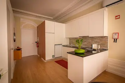 a kitchen with white cabinets and a green apple on a counter at São Domingos Flowers Apartments in Porto