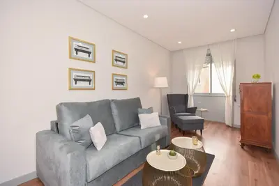 a living room with a gray couch and a chair at Rosario's Boutique Apartments in Porto