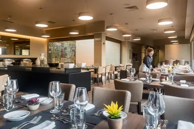 a bar in a restaurant with black stools at Hotel Dom Henrique - Downtown in Porto
