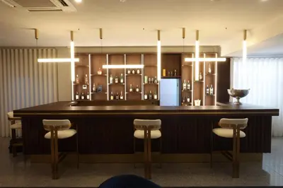 a bar with chairs and a refrigerator in a room at Hotel America in Porto