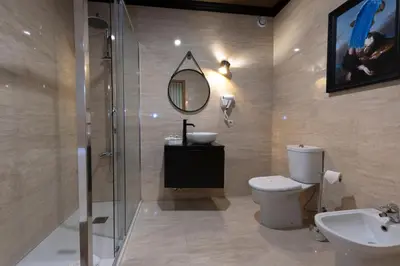 a bathroom with a toilet and a sink and a mirror at Hotel America in Porto
