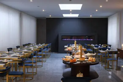 a long dining room with tables and chairs at Hotel America in Porto