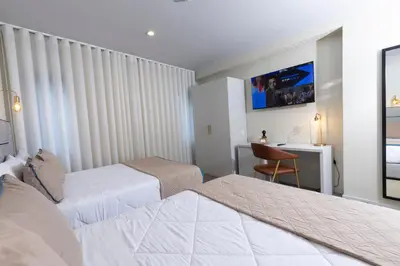 a hotel room with two beds and a desk at Hotel America in Porto