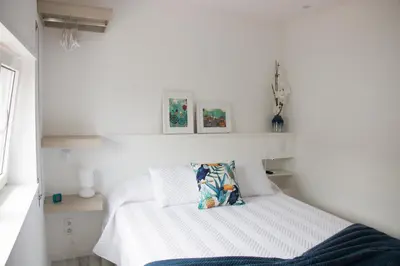 a white bedroom with a bed with a white headboard at Casa d'Avó in Porto