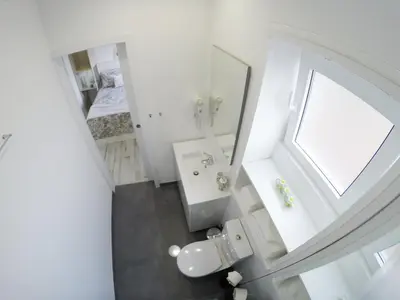 a white bathroom with a sink and a mirror at Casa d'Avó in Porto