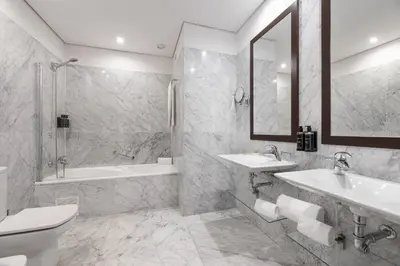 a bathroom with two sinks and a tub and a toilet at Eurostars das Artes in Porto