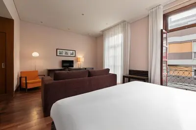 a living room with a couch and a chair at Eurostars das Artes in Porto