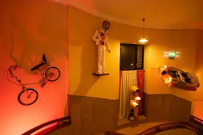 a bathroom with a statue of a man with a bike on the wall at Pao de Acucar Hotel in Porto