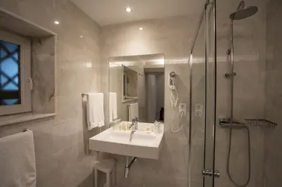 a bathroom with a sink and a shower at Pao de Acucar Hotel in Porto