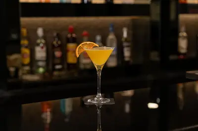 a martini glass with an orange slice on a bar at HF Ipanema Porto in Porto