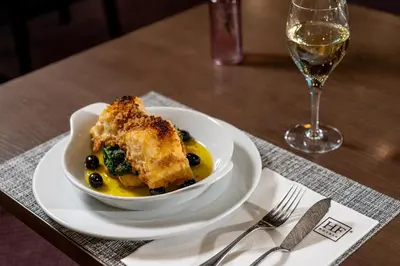 a bowl of food on a table with a glass of wine at HF Ipanema Porto in Porto