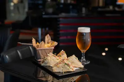 a table with a plate of food and a glass of beer at HF Fénix Porto in Porto