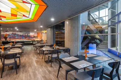 a restaurant with tables and chairs and a large window at HF Fénix Porto in Porto